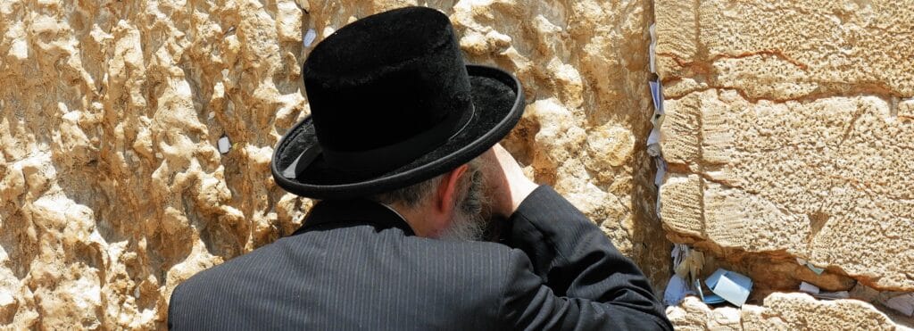 En bild på en judisk man som ber vid Västra muren i Jerusalem