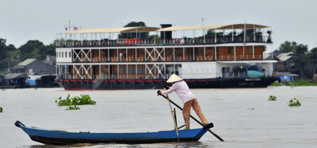 En bild på en man som ror en båt på Mekong